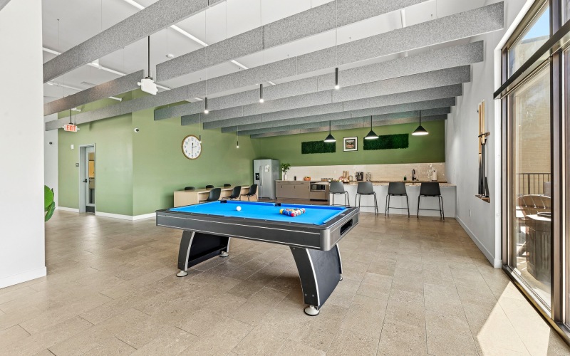 room with a pool table and table with chairs